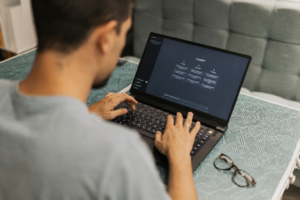 Home A man searches on a black laptop using the AI search software, ChatGPT.
